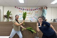 2025-Volunteer-Appreciation-Breakfast-President-and-CEO-Anna-Neubauer-Hanging-Decor-with-Operations-Coordinator-Meg-Taufalo-and-Volunteer-Services-Manager-Isa-Cortina